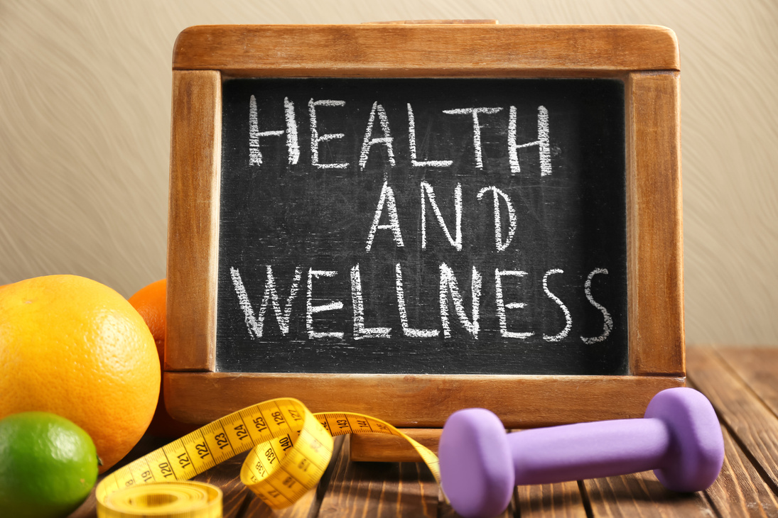 Phrase "Health and Wellness" Written on Blackboard, Fruits and Dumbbell on Wooden Table